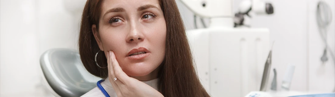 Person Holding Cheek While Experiencing Dental Discomfort